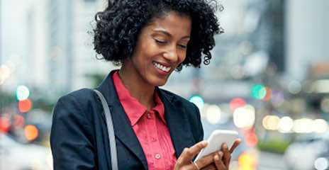 Female is looking at her phone and smiling