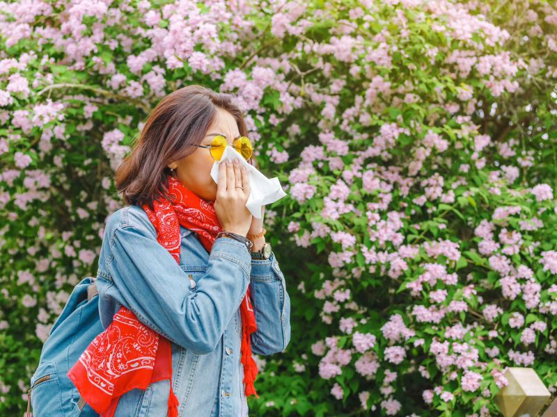 young-woman-blows-nose-outside