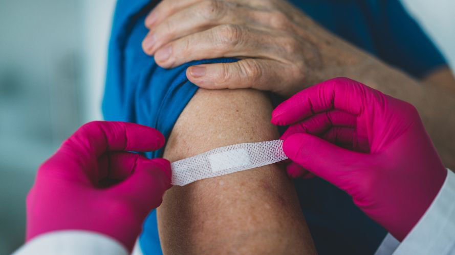 médico-coloca-un-apósito-sobre-el-lugar-de-la-vacuna-en-el-brazo-del-paciente