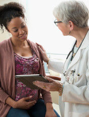 Pregnant woman with older female doctor