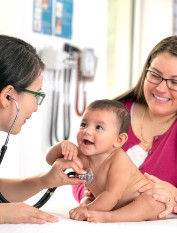 Family with baby meeting with young doctor