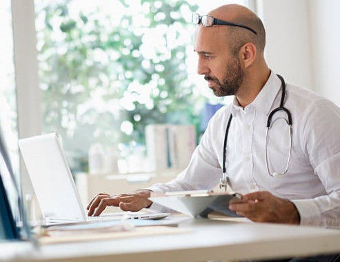 Young male doctor on computer