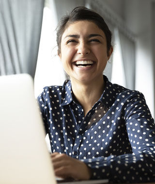 smiling woman sitting at a computer