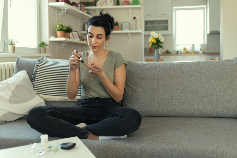 Women Checking Blood Sugar Levels by Glucose Meter at Home in the Living Room. Medicine, Diabetes, Glycemia, Health Care and People Concept