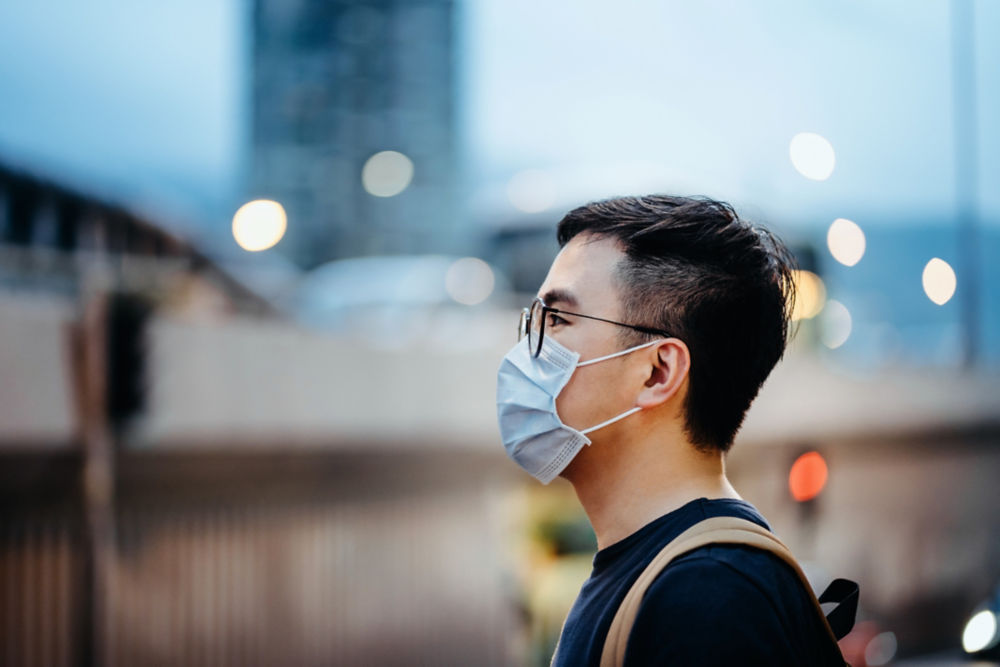 Portrait of young Asian man with face mask to protect and prevent from the spread of viruses in the city