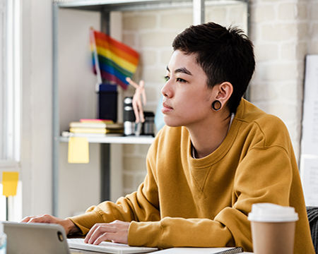 Young Asian tomboy woman in casual attire working from home in living room