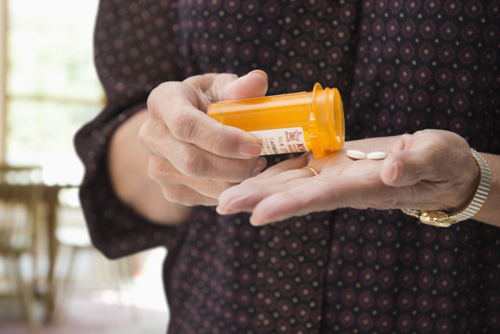 Woman holding medication pills.