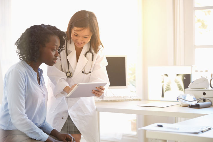 Médico y mujer leyendo una tableta digital