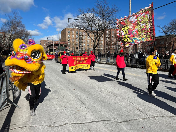 Los bailarines del león y los voluntarios marchan por la ruta del desfile