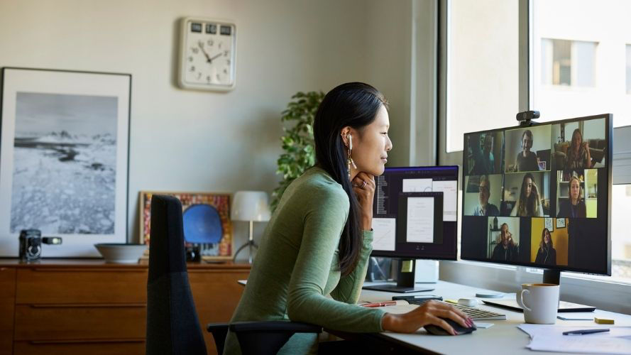 Young professional woman sitting at a desk on a video call in her home office..