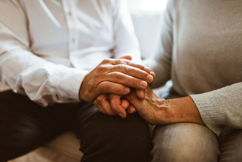 retirement couple holding hands