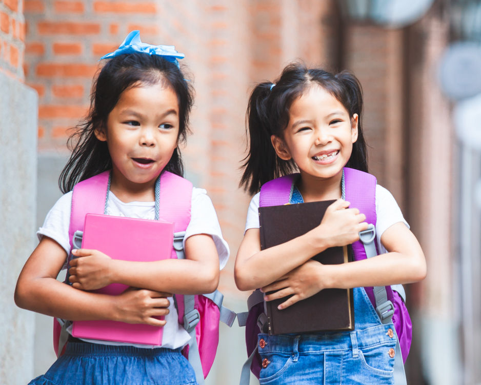 Niños que van caminando al hogar desde la escuela