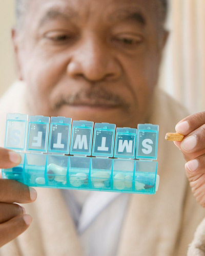 senior goes over his weekly medicine on pillbox