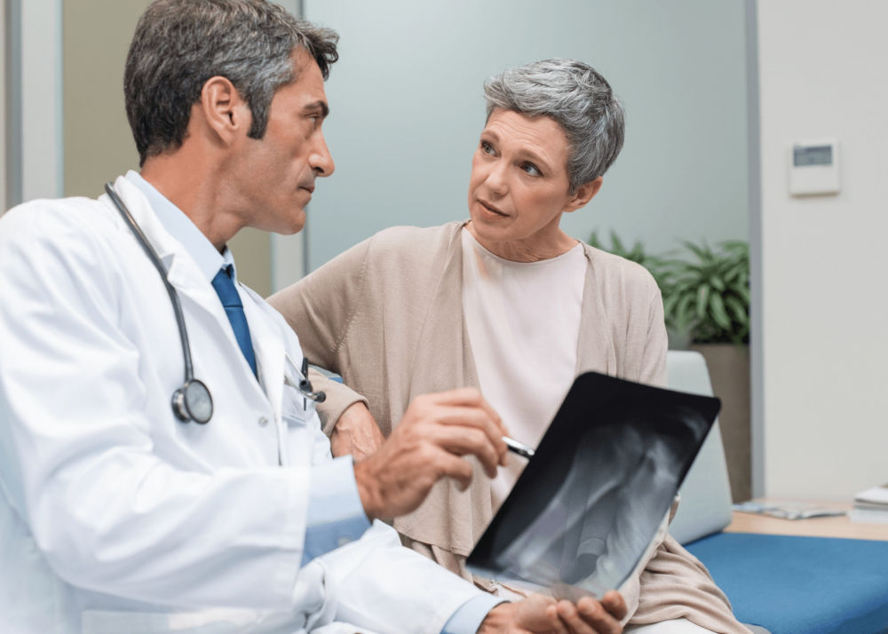 mature-woman-viewing-x-ray-with-doctor