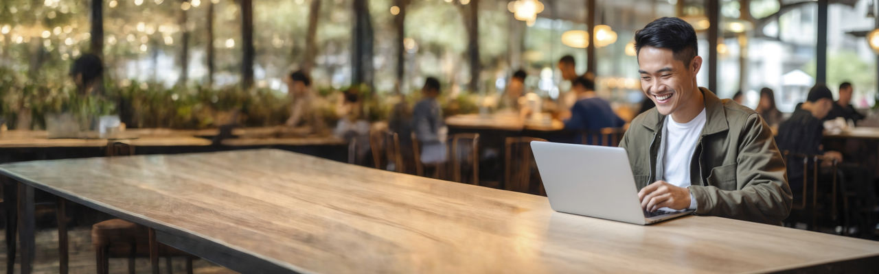 man looking att laptop in cafe