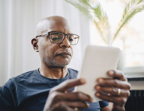 adulto mayor está usando su iPad para buscar planes de Medicare