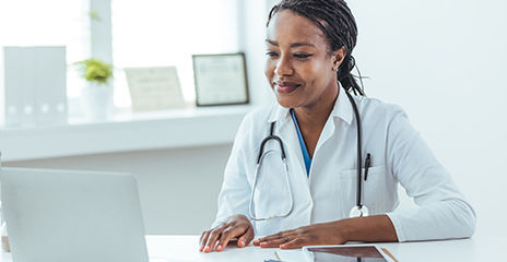 doctor smiling and looking at computer in the office