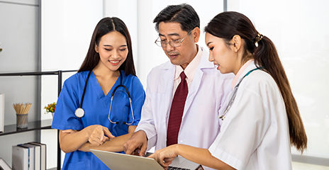 happy medical team standing and meeting with laptop computer