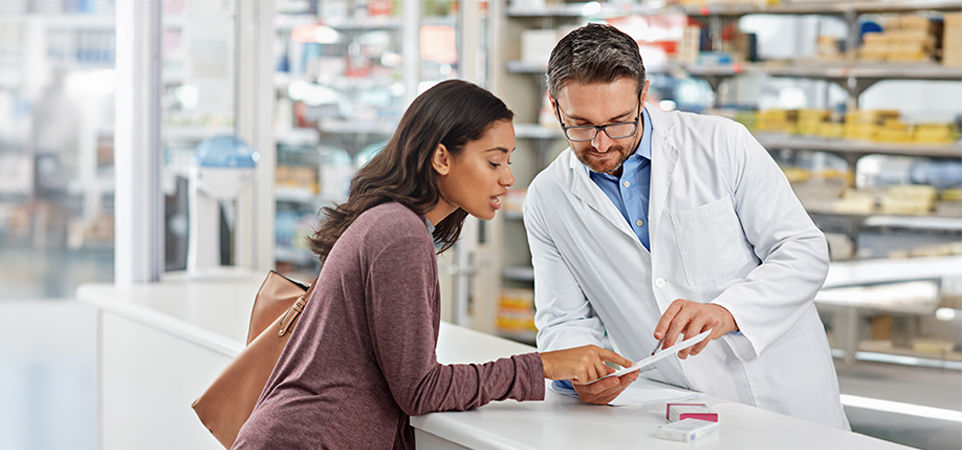 Farmacéutico hablando con un cliente en la farmacia