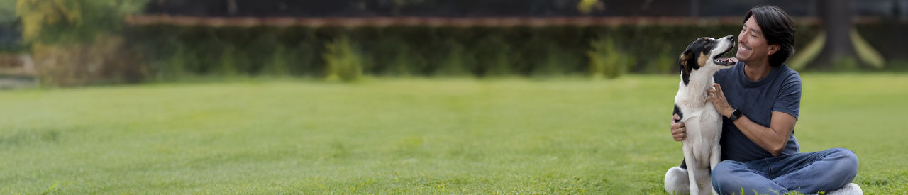 hombre esperanzado sonriendo con su perro afuera