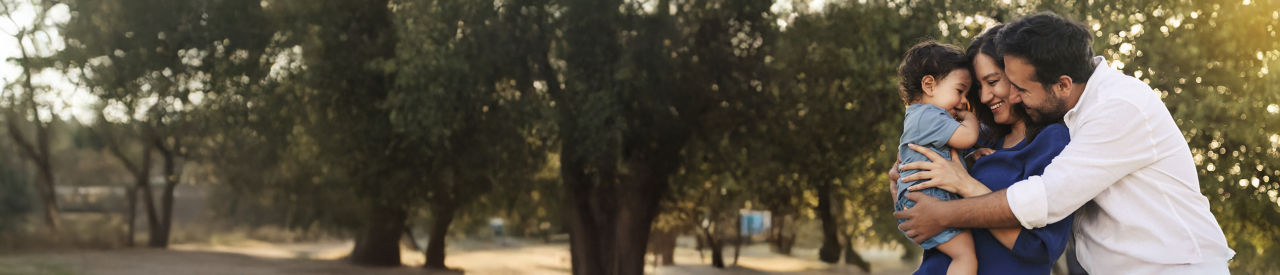 Happy family in the park at sunset