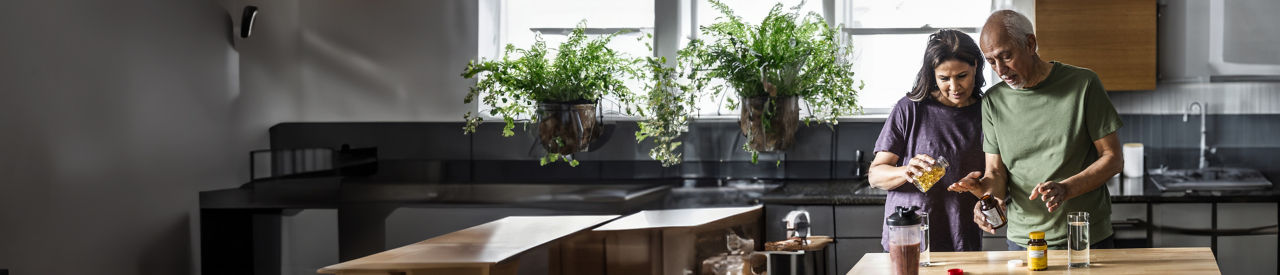 two people in kitchen taking medicine