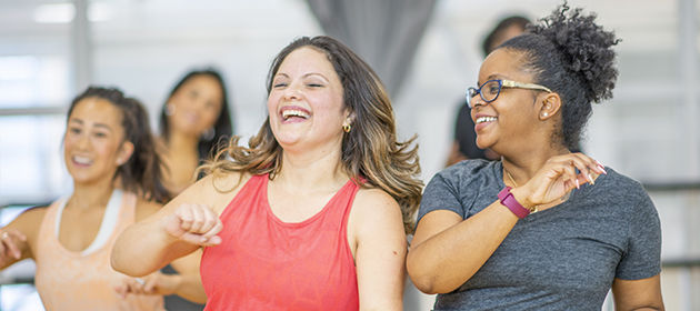 Diverse group of women in dance fitness exercise class.