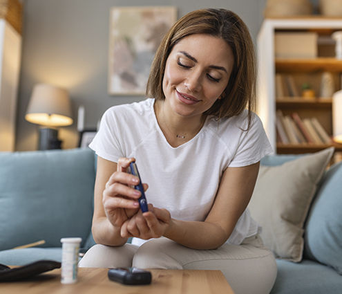Woman checking her blood sugar levels to test for diabetes maintenanc
