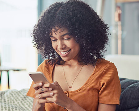 smiling woman using mobile device at home