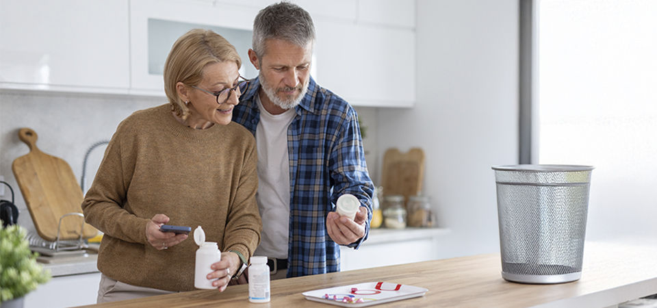 Close up of Senior citizen female holding bottles of prescription medicine.