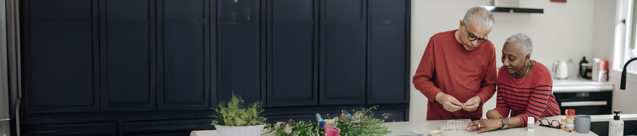 seniors taking medication in kitchen 