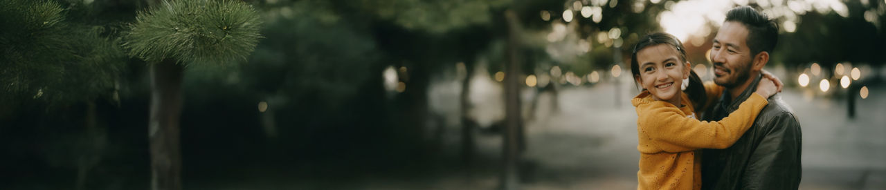 father holding young child outside