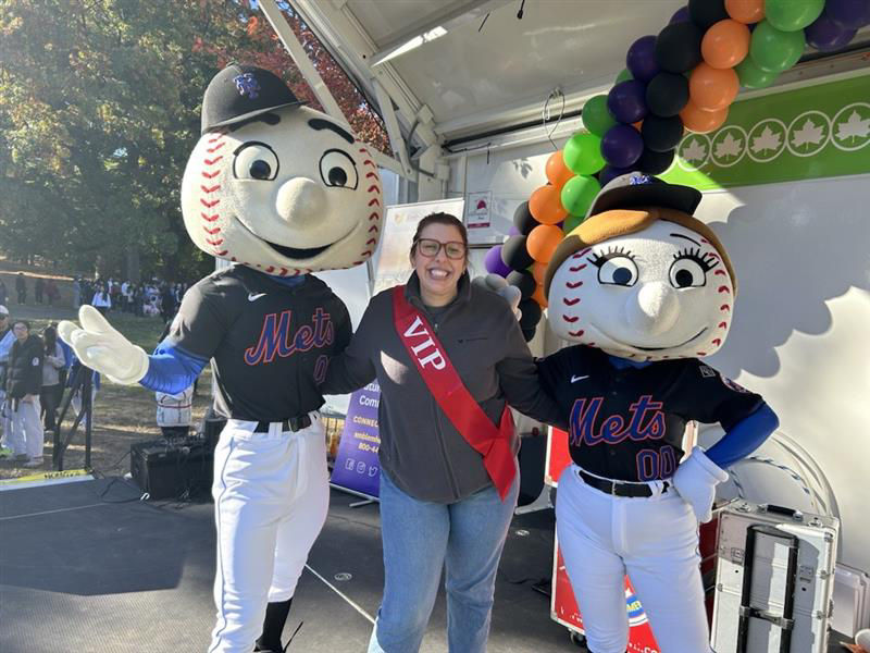 Stephanie Wilson, especialista en eventos de EmblemHealth, con el Sr. y la Sra. Met en el desfile de Halloween de College Point. 