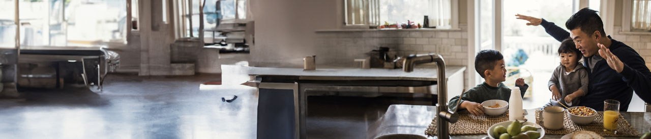 hombre sentado en la cocina con sus dos hijos