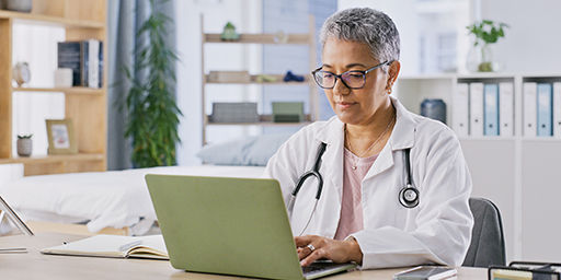 doctor uses a laptop in her office