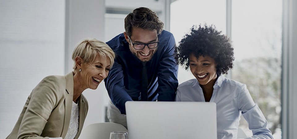 colleagues around a computer in office 