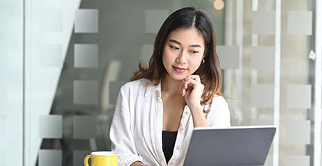 woman on computer and drinking coffee