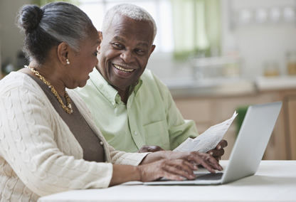 Marido y mujer en la computadora leyendo un documento