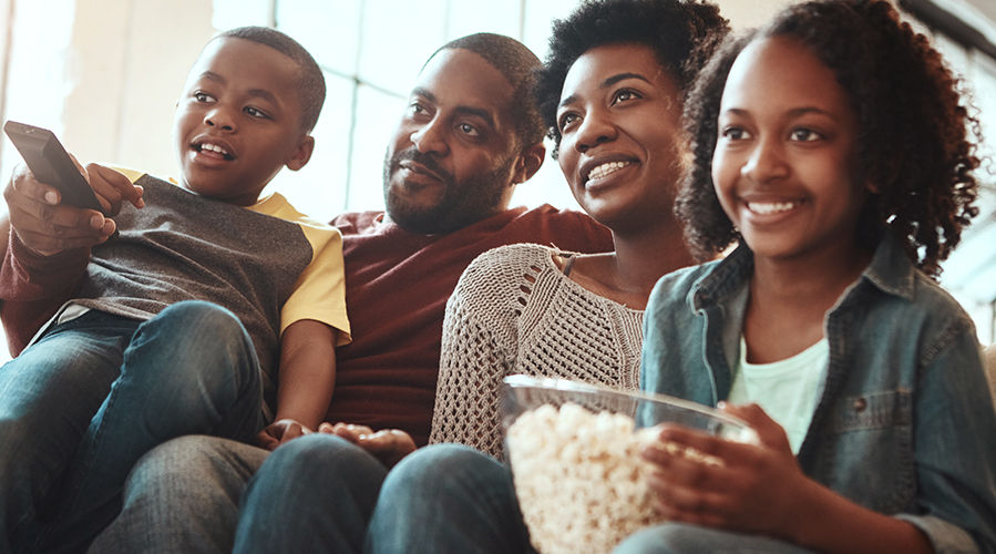 Family prepares to watch a movie and eat popcorn together.