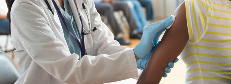 Doctor disinfecting arm of patient in volunteer clinic