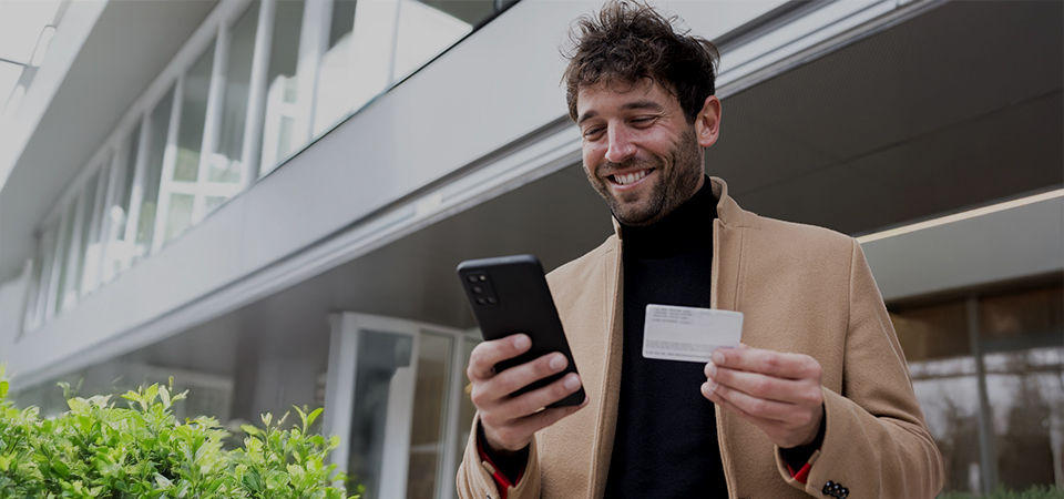 man holding a card and looking at phone