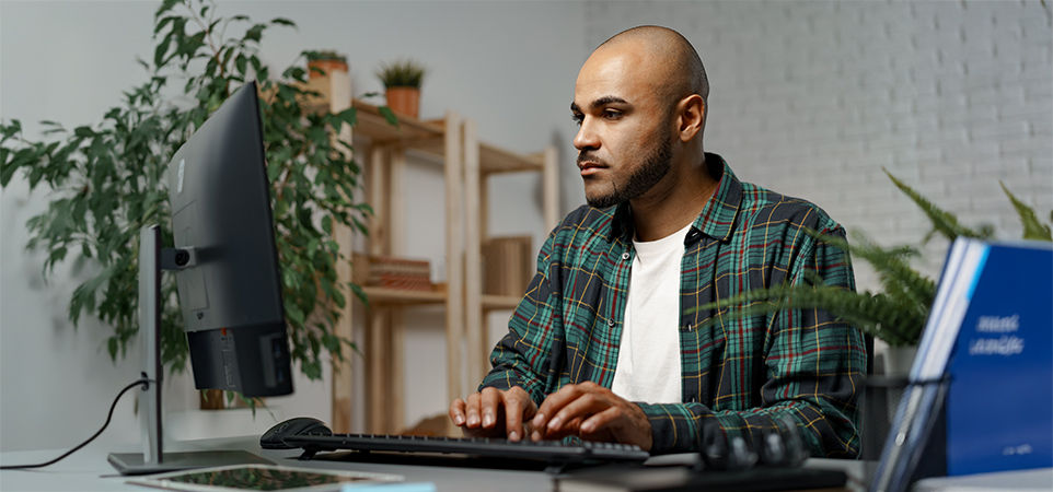 hombre frente a una computadora en casa