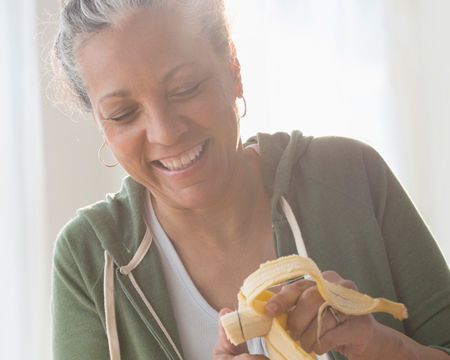 mujer rebanando una banana