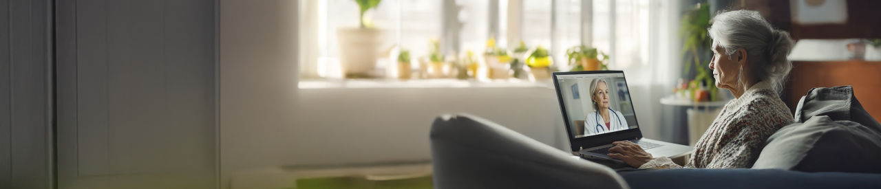 hombre mayor con una computadora portátil en la cocina