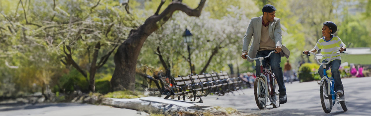 father and son riding bikes in the park 