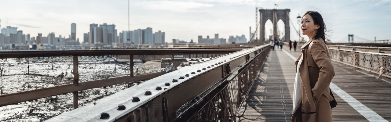 person standing on bridge with hands in pocket