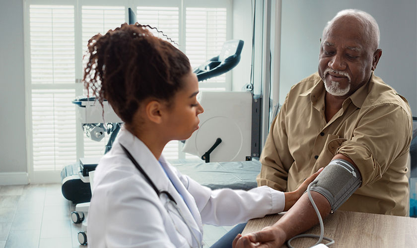 Senior male patient getting his blood pressure taken by a female health care provider