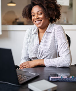 Businessman sitting in office smiling during a video call. African woman on a video conference meeting at office.