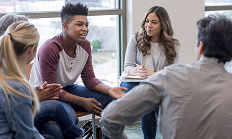 Group of young adults focusing on mental health with a coach