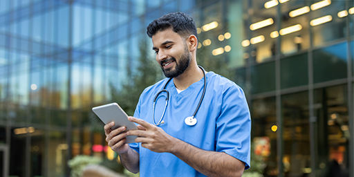 doctor looking at tablet outside